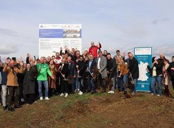 Quelle: Gemeinde Wölfersheim Das Bild zeigt eine große Gruppe von Menschen auf einer Baustelle. Die Personen im Vordergrund halten Schaufeln. Einzelne Personen jubeln.