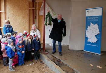 Das Bild zeigt Kinder und Erwachsene beim Richtfest