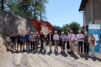 Auf diesem Bild sieht Baubeteiligte auf einer Baustelle die den ersten Spatenstich setzen 