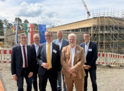 Quelle: Hansestadt Warburg, Pressestelle Auf dem Bild sind sechs Männer vor einer Baustelle erkennbar. Im Hintergrund befindet sich die zu sanierende Einrichtung.