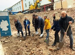Quelle: Stadt Alfeld (Leine) Das Bild zeigt eine Reihe an Menschen beim symbolischen Spatenstich.
