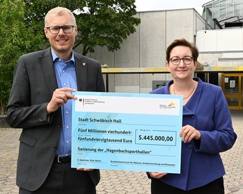 Das Bild zeigt eine Frau und einen Mann, die gemeinsam einen Förderscheck halten.