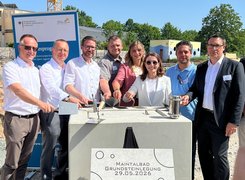 Quelle: Margot Trinter Acht Personen, die für ein Bild posieren. Sie versenken eine Zeitkapsel.